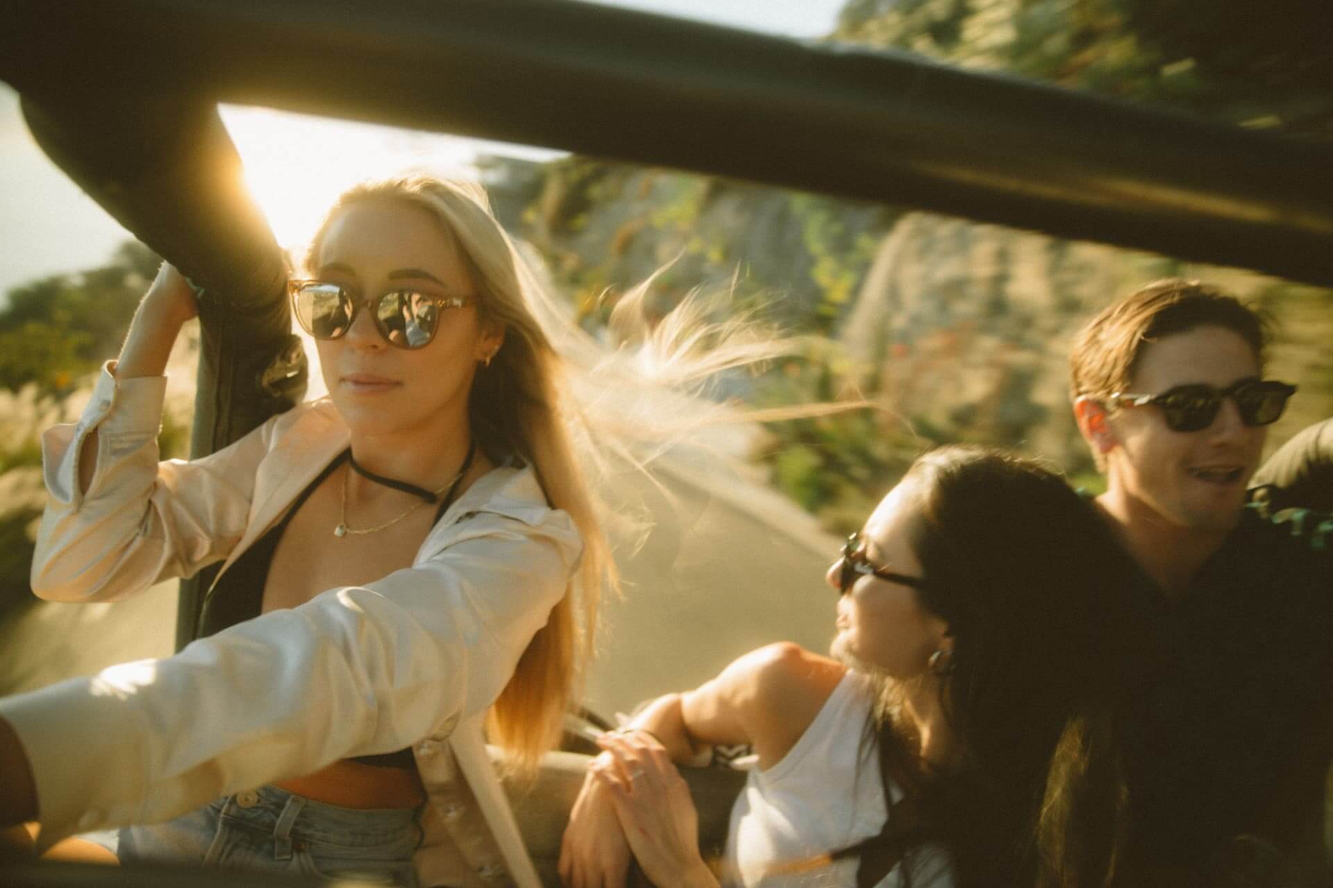 Creators riding together in an open car at golden hour