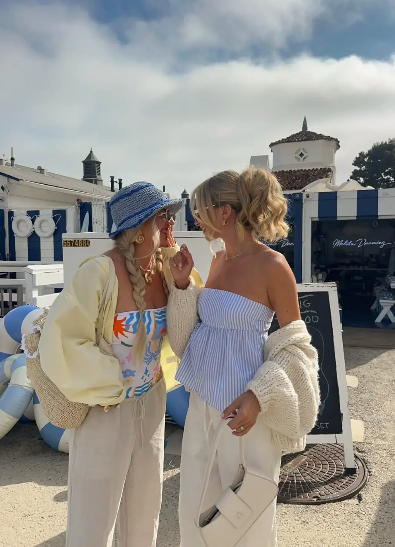 Two creators laughing together outdoors by the beach