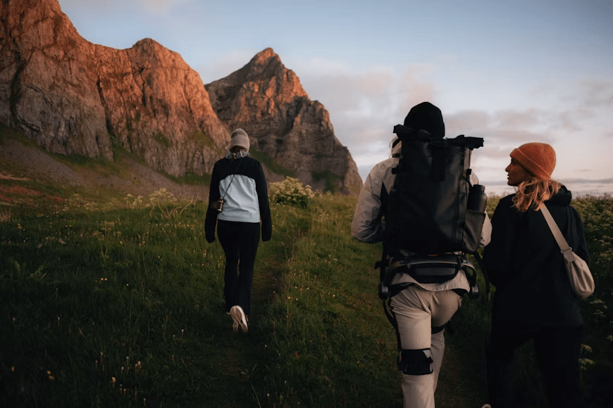 Three hikers walking through a mountain landscape